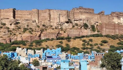 Inde : Un quartier de maisons bleues sont aux pieds de remparts de grès rose d'une citadelle
