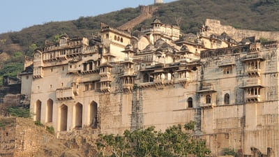 Inde : Une citadelle avec de nombreux bâtiments en pierre claires, est accrochée à une colline
