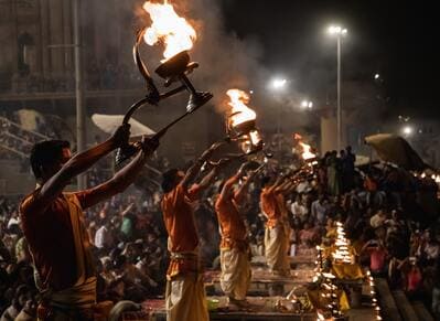 Inde : Des hommes alignés brandissent dans la nuit des candélabres enflammés