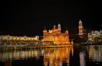 Inde : Un temple serti d'or est pris en photo de nuit. Il se reflète dans les eaux d'un lac