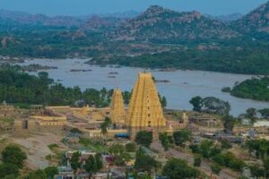 Inde : Un paysage de rivière et de verdure avec au centre une tour ressemblant à une pyramide