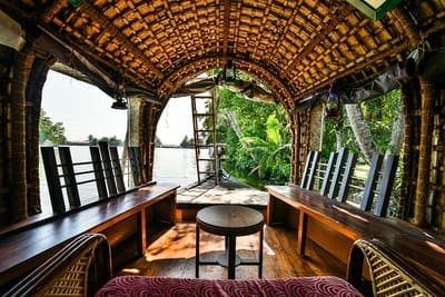 Inde : Intérieur d'un bateau avec des bancs en bois sur les côtés et un toit de palmes tressées