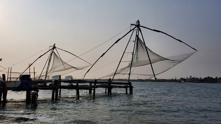 Inde du Sud : Des filets à balancier sont en position relevés, au coucher du soleil