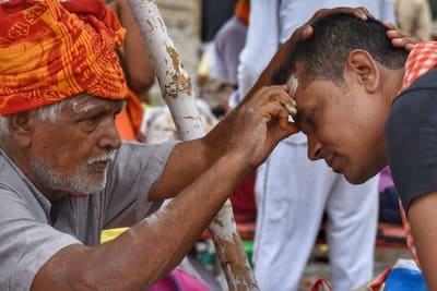 Inde : Un homme avec un turban béni un autre homme en lui déposant de la cendre sur le front