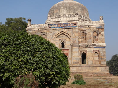 Inde, New Delhi : Derrière des arbustes, un vieux bâtiment en pierre