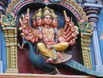 Inde : Une statue de couleurs représentant une déesse à plusieurs têtes et bras, posée sur un paon