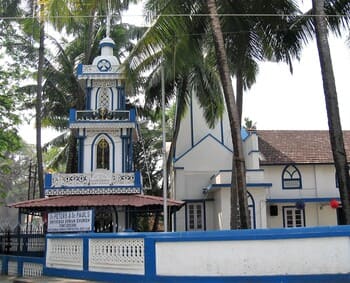 Inde du Sud : Une petite église blanche à lisérés bleus est sous des cocotiers