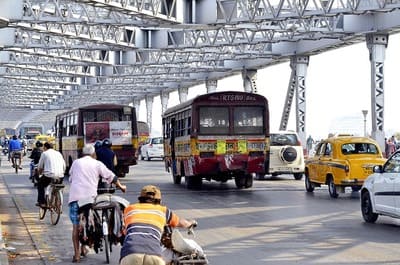 Inde : Des bus et des hommes à vélo s'engagent sur un pont métallique