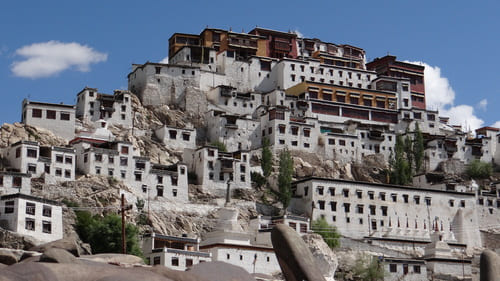 Ladakh : Une colline est recouverte de maisons blanches avec au sommet un monastère de couleur ocre