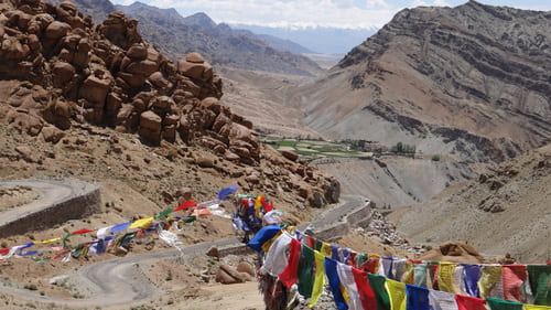 Ladakh : Des drapeaux de couleurs volent au vent devant une perspective d'une vallée rocheuse